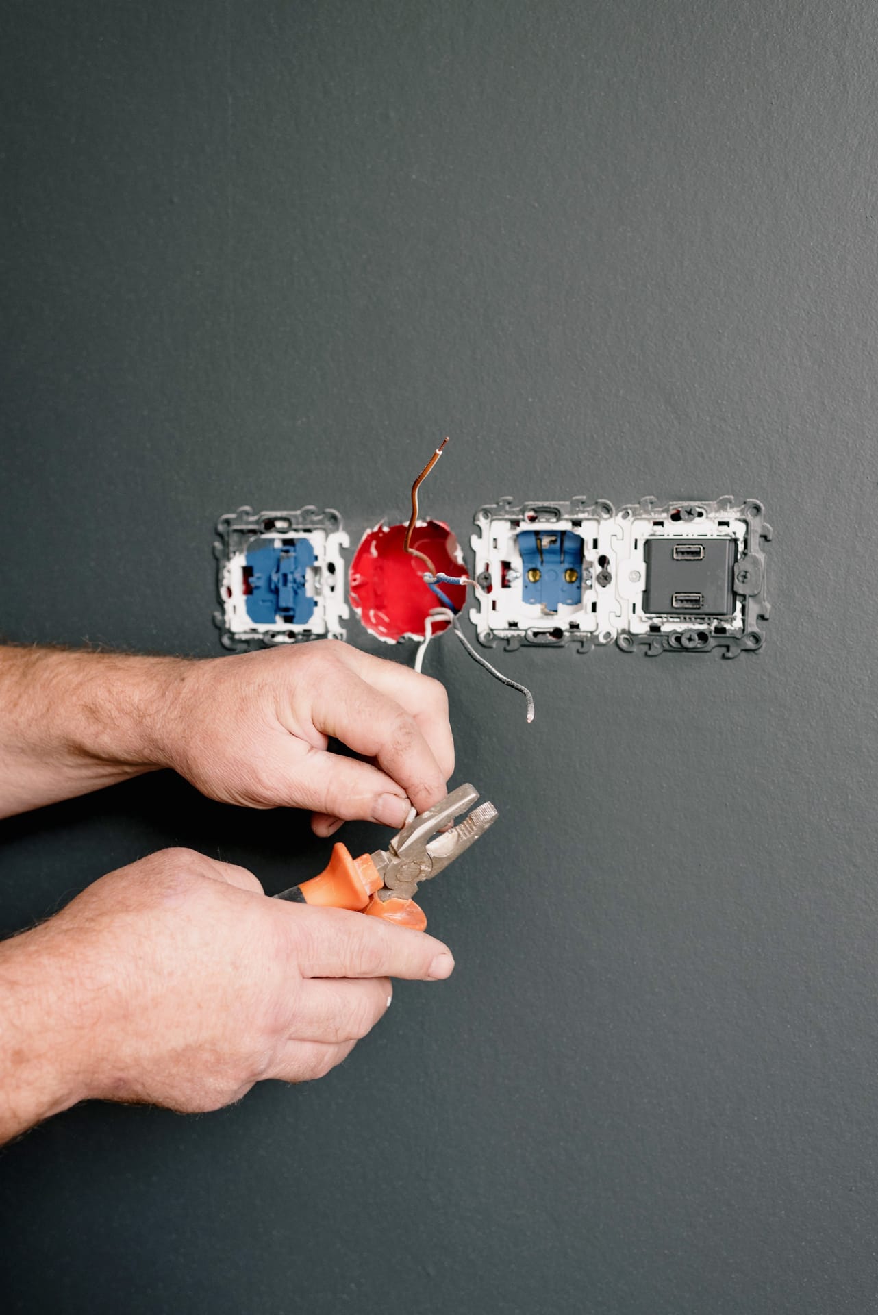 An electrician carefully preparing wiring for a wall socket